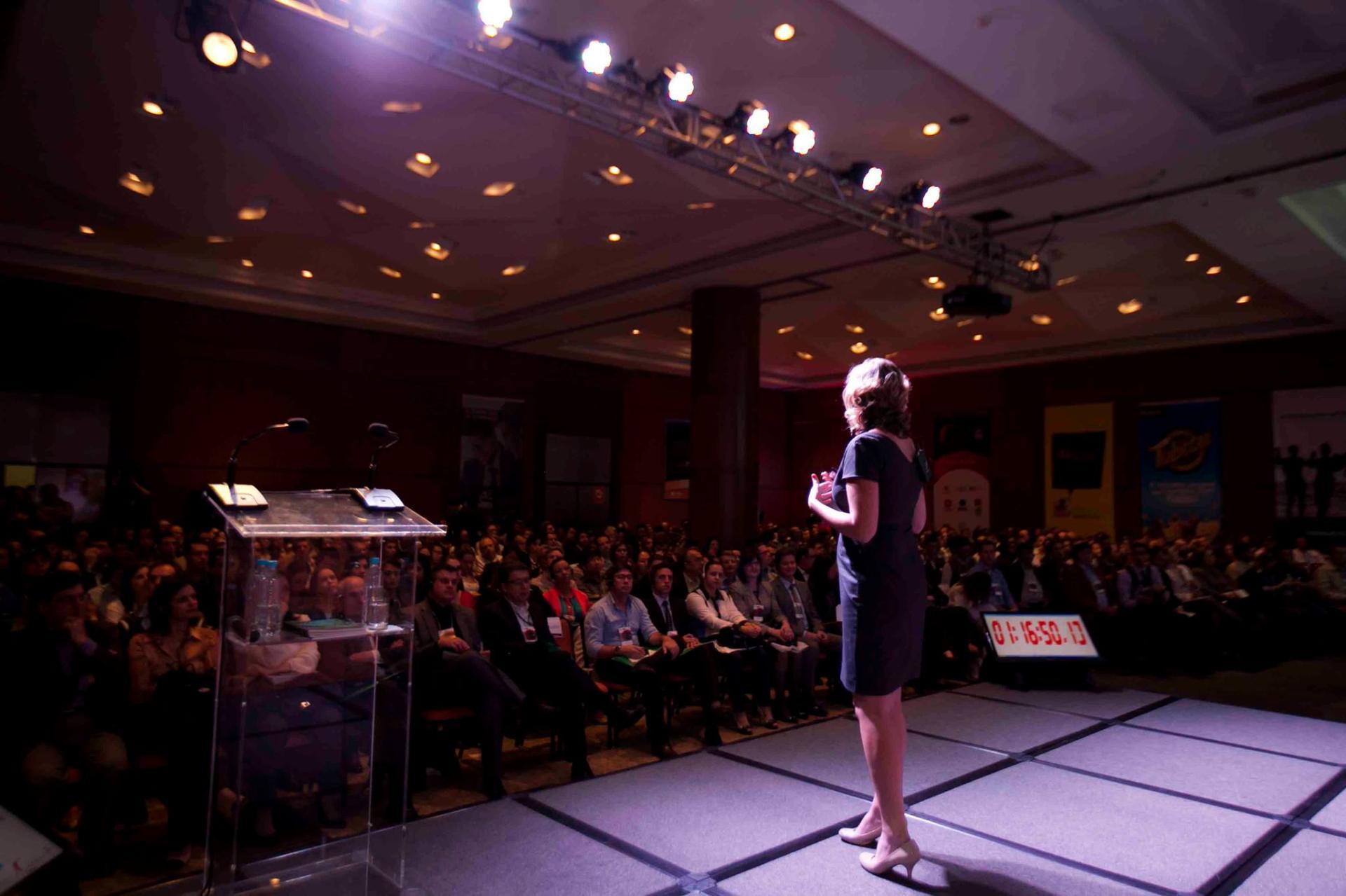 Woman speaking on stage at a business conference